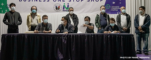 MOA SIGNING Mayor Nelson Legacion (sitting, 2nd from left) confers with NICC Managing Director Benigno Angelo Imperial (sitting, first from left) during the memorandum of agreement signing on February 22, 2021. Photo also shows NICC President Philip Imperial (at Legacion’s right) signing the document with Vice Mayor Cecilia V. De Asis while City Councilors (from right to left) Joselito del Rosario, Antonio Beltran, Jose Perez, Vidal Castillo, Esteban Gregorio Abonal, and Ghiel Rosales look on.