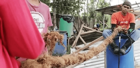 ROPE MAKING Workers of the Naga City Sanitary Landfill help each other make a coir rope.