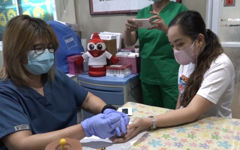 Si Grace Guevara, medical technologist kan Social Hygiene Clinic (sa wala) pigtutugduan an sarong barangay health worker nin tamang paggamit kan dengue antigen test kit.